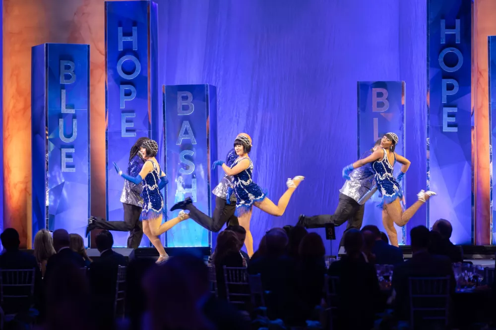 The Blue Hope Bash program begins with a rousing speakeasy-inspired performance by a flashy dance troupe decked out in silver and blue.