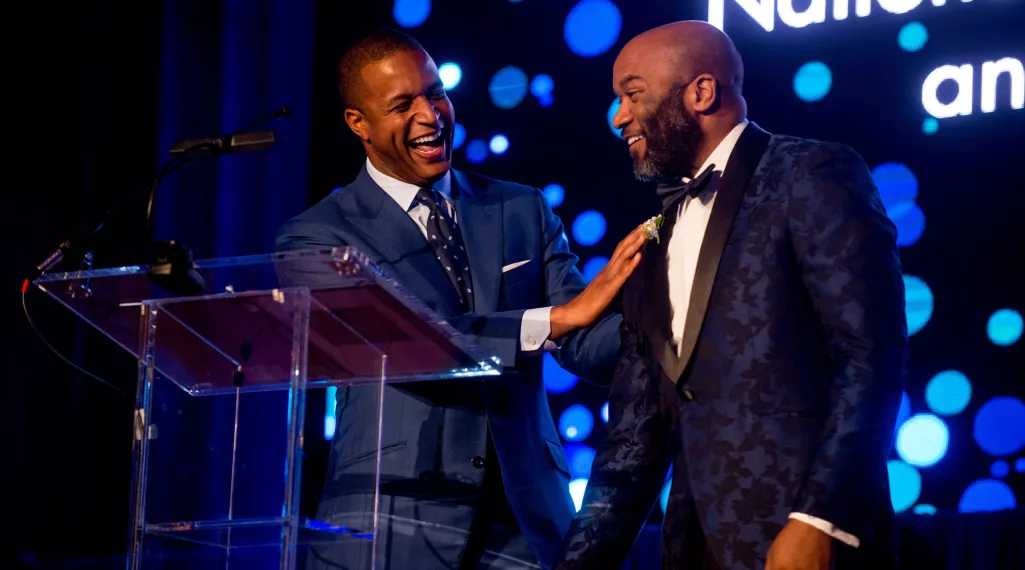 Craig Melvin greets his brother on stage at the Colorectal Cancer Alliance's Blue Hope Bash.