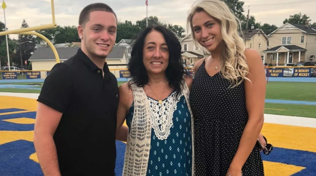 Dawn Benedetto Failace with her children on a football field.