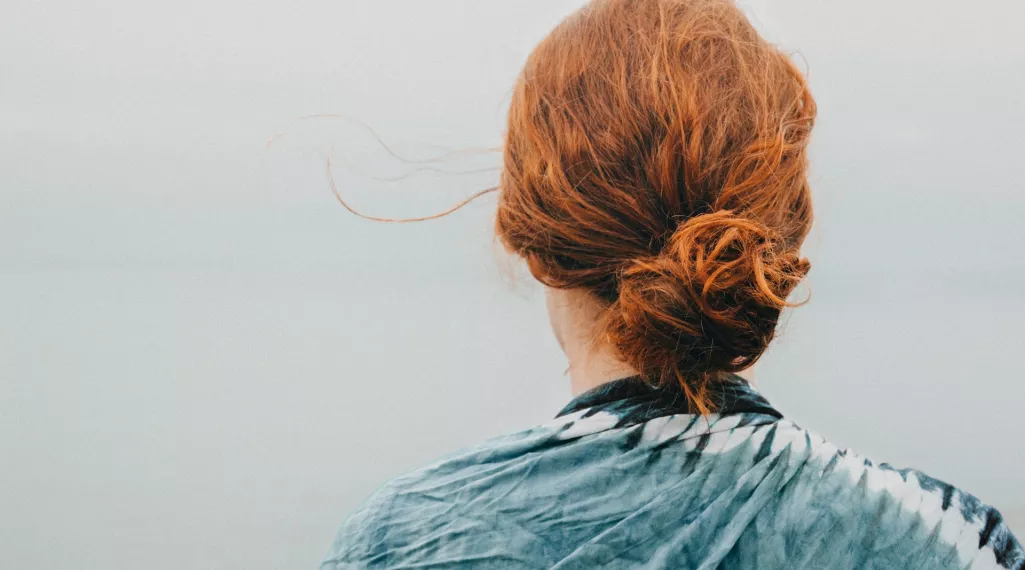 A rear portrait of a woman with red hair