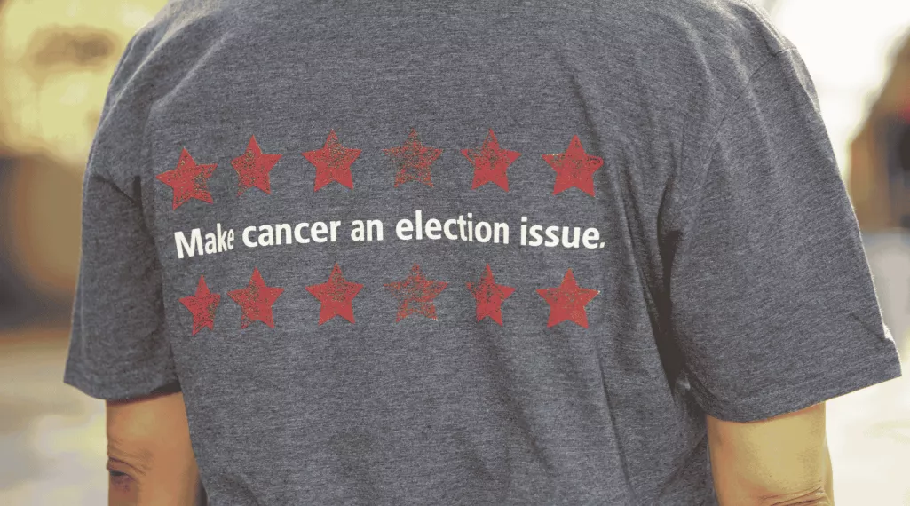 An image of the back of a T-shirt, which has written on it, "Make cancer an election issue."