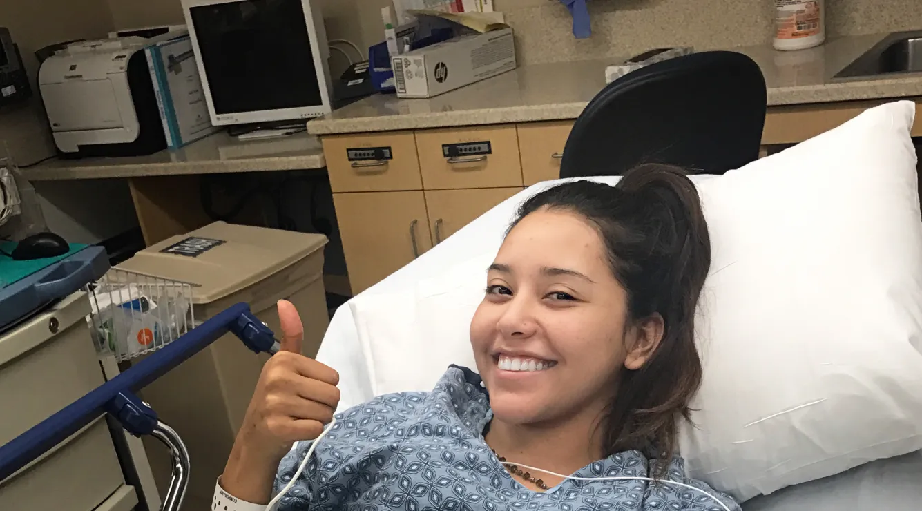 young Latin woman smiling in hospital bed