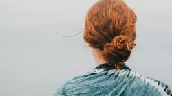 A rear portrait of a woman with red hair