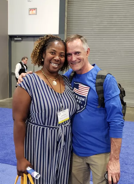 Black woman and man smiling at Allycon