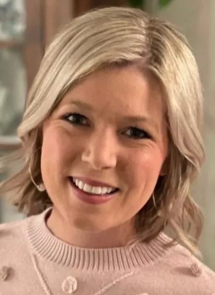 Young blonde woman in pink sweater smiling