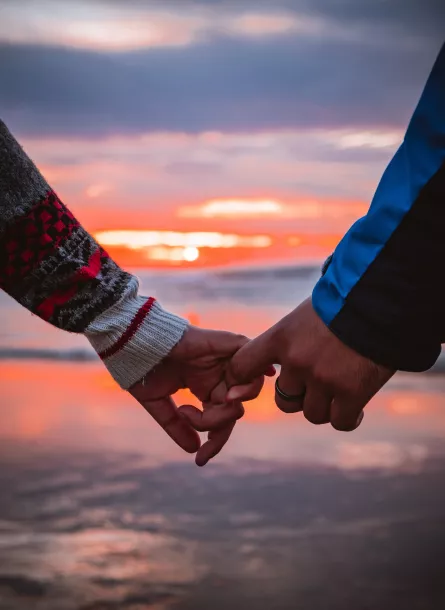 couple holding hands at sunrise