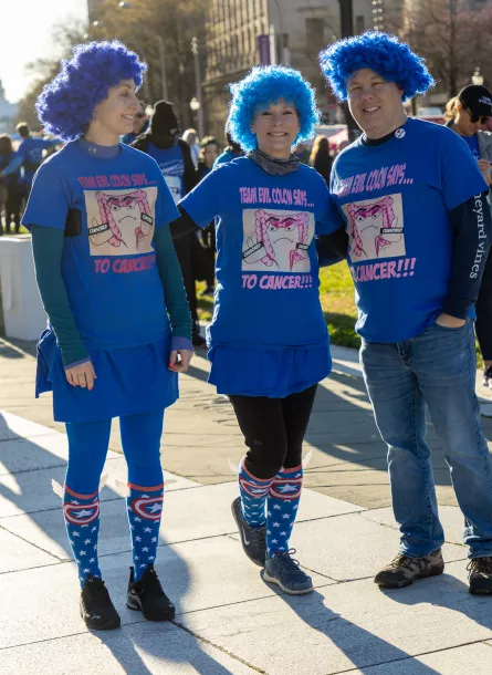 Three-person walk team named "Team Evil Colon" smiling