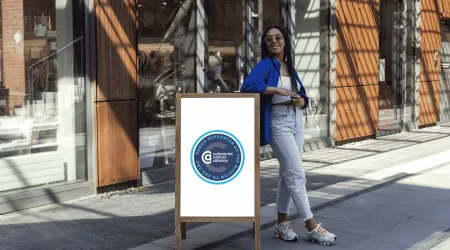 Colorectal Cancer Alliance emblem reading 'Proud Supporter of the Mission to End CRC,' displayed on a sandwich board sign.
