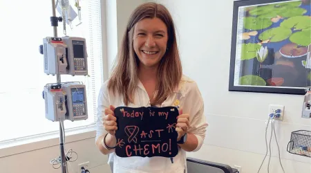 Kat in a hospital with a sign that says last chemo