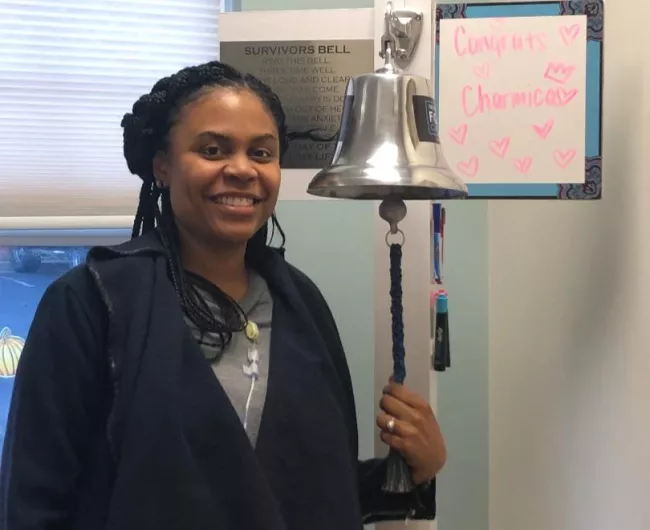 Woman ringing cancer bell at hospital