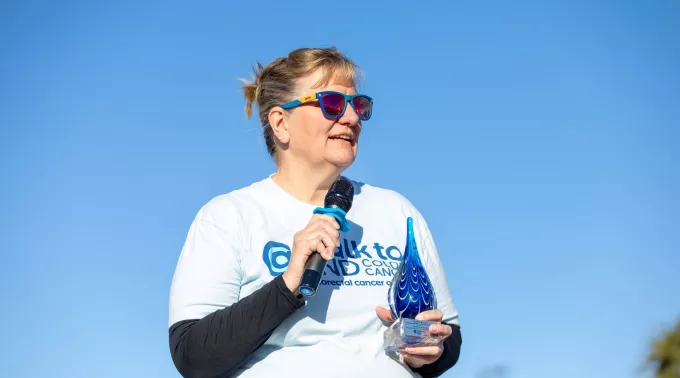 Female with microphone and award at walk
