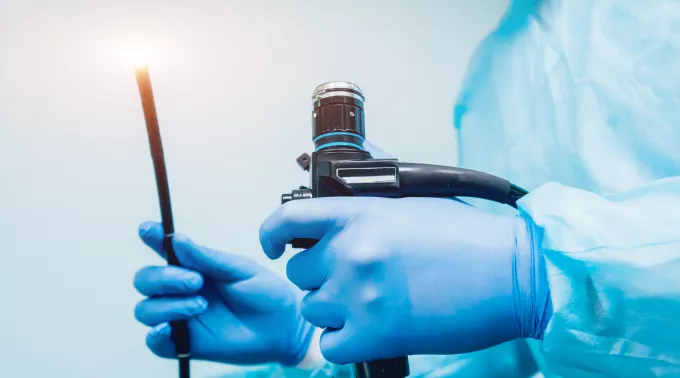 doctor holding scope in blue