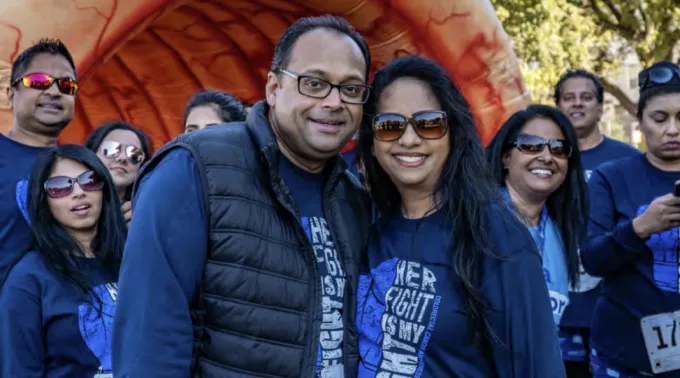 A man and woman in blue gear participate in the Walk to End Colon Cancer.