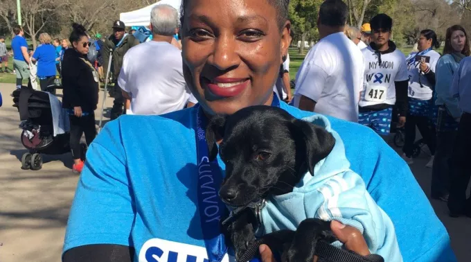 Black woman CRC survivor posing with black dog