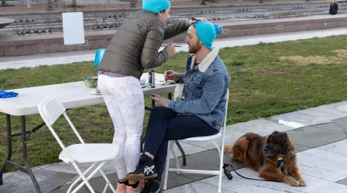 Woman paints man's face