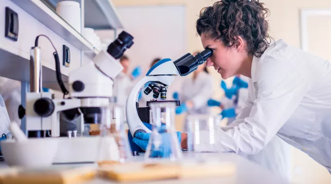 woman in lab with microscope