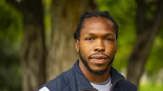 young black man in blue vest