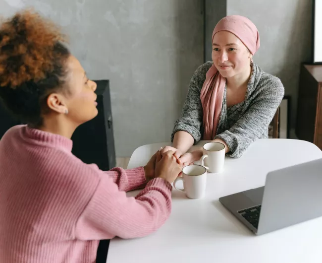 two woman holding hands conversing