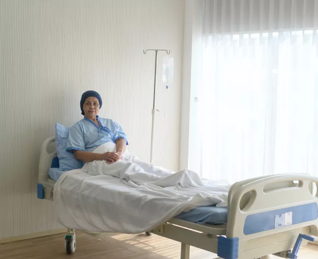 Asian elder woman sits in hospital bed