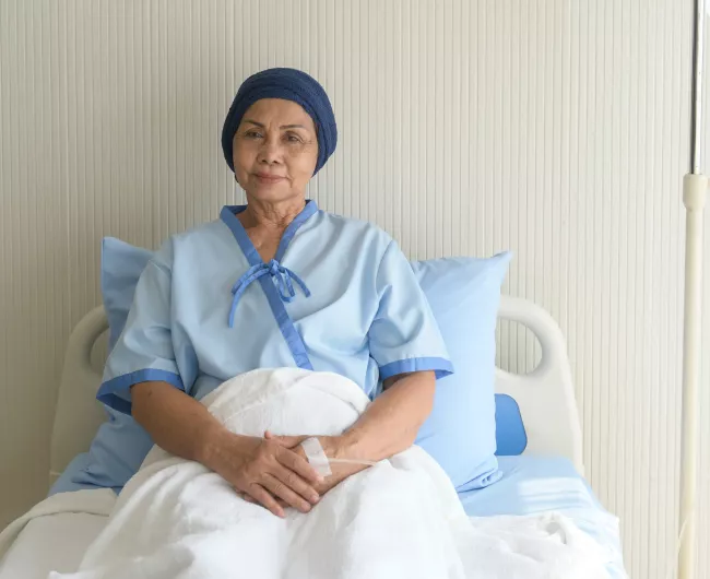 Asian elder woman smiles in hospital bed