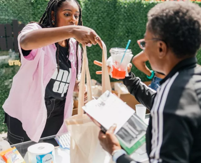 BLKHLTH team members interact with a community member at an in-person event