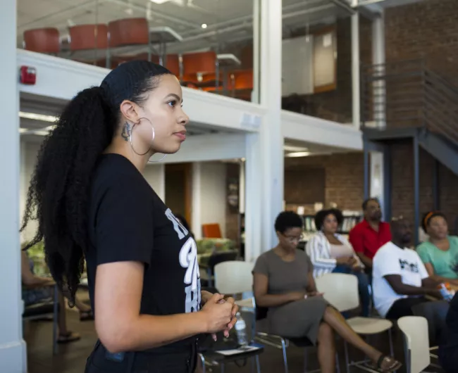 A woman speaks to a crowd. 