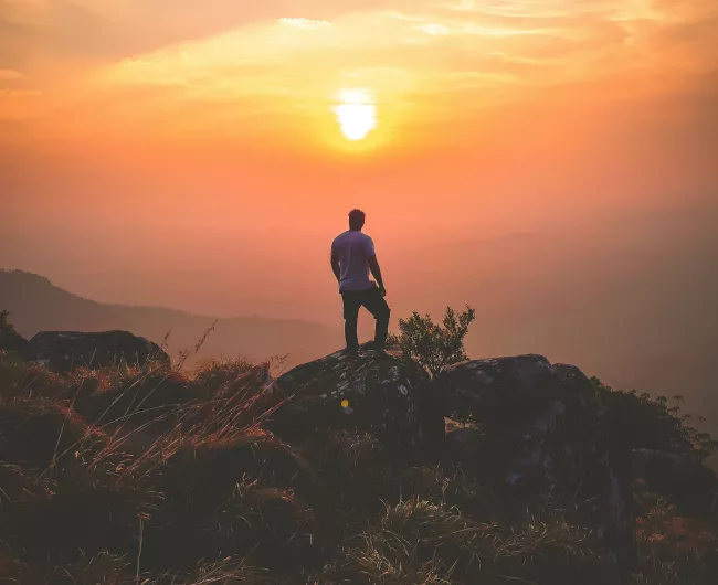 man hiking with sunset
