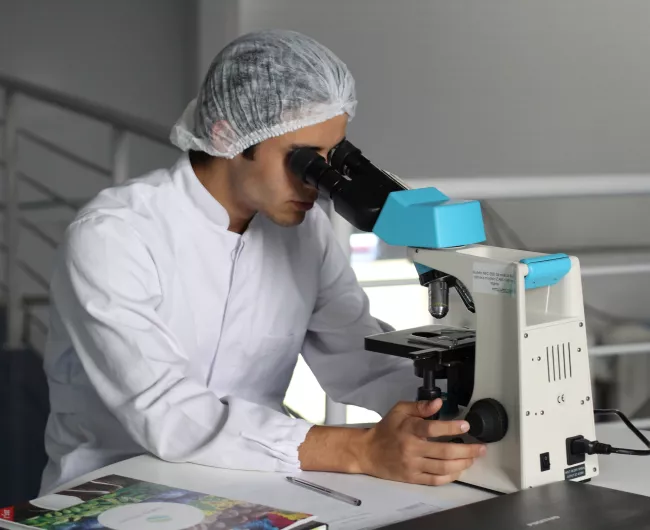 man looking into microscope 