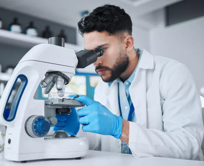 man looking through microscope
