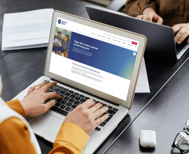 A woman on a computer looks at the Alliance's screening quiz. 