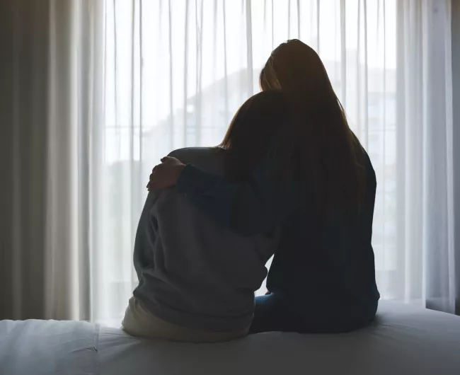 people hugging on bed