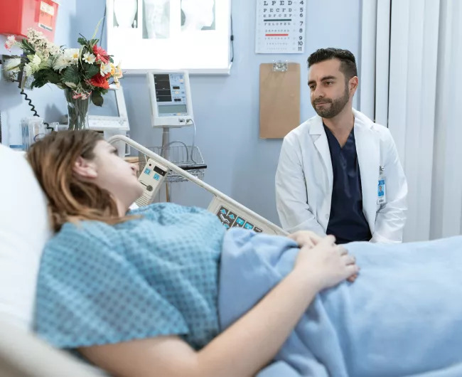 doctor speaking to patient in bed