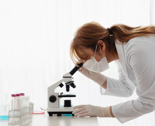 female scientist examines specimen