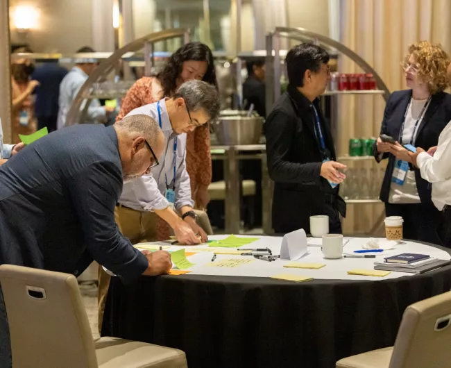 Researchers networking, speaking and thinking around a table at the Cure CRC Summit