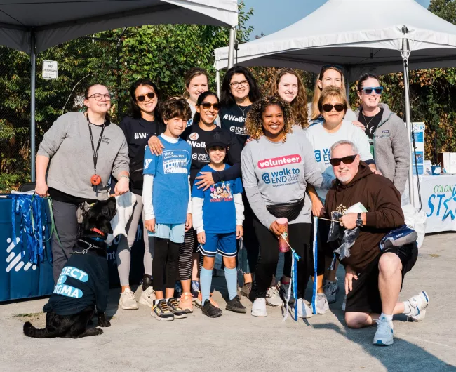 Group with dogs smiling at camera at a walk