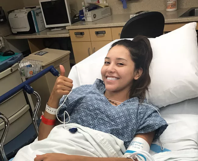 young Latin woman smiling in hospital bed