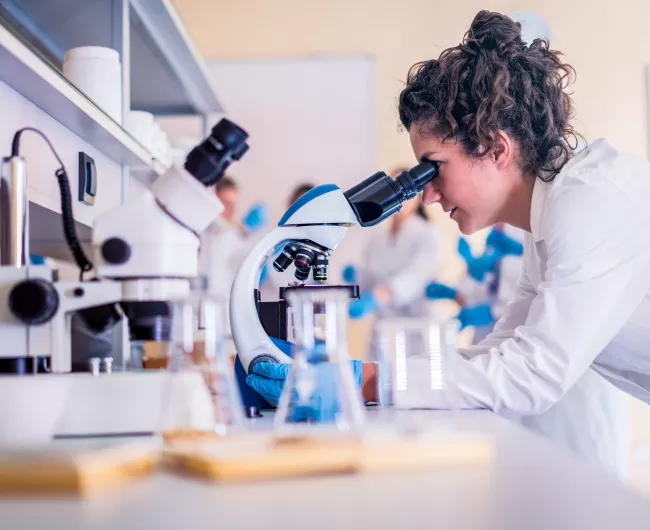woman in lab with microscope