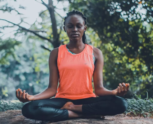 woman orange shirt meditating 