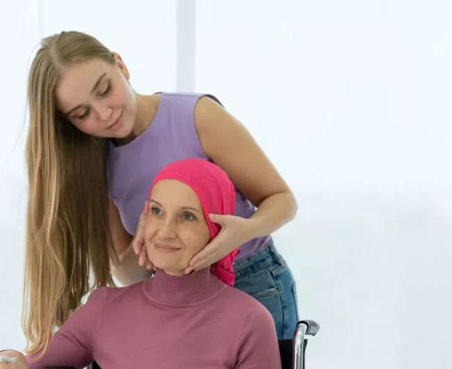 scarfed mother in wheelchair with teen daughter