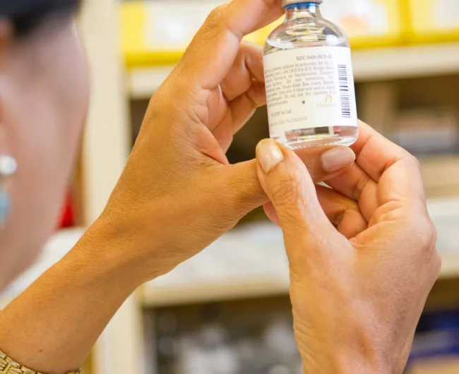 woman pharmacist holds bottled liquid