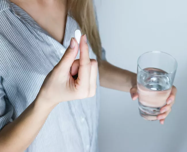 while pill in woman's hand
