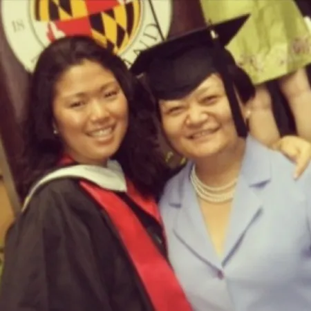 Kate Shin and her mother, Lynn, smiling together at Kate’s graduation ceremony. Kate wears a black cap and gown with a red stole, and Lynn wears a light blue suit with a pearl necklace.